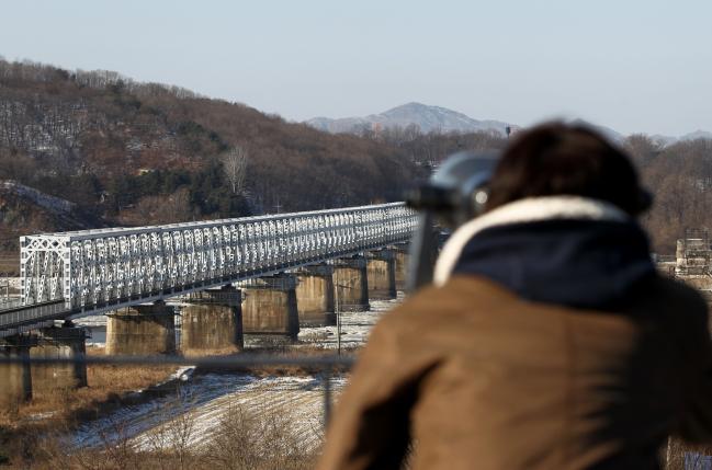 © Bloomberg. A visitor using binoculars looks north at the Imjingak Pavilion near the Demilitarized Zone (DMZ) in Paju, South Korea, on Monday, Dec. 26, 2011. 