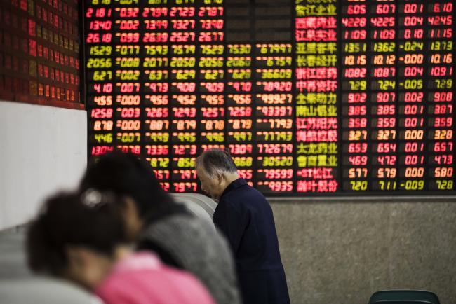 © Bloomberg. Investors stand at trading terminals in front of electronic stock boards at a securities brokerage in Shanghai, China, on Friday, Oct. 13, 2017. A number of economic indicators show 