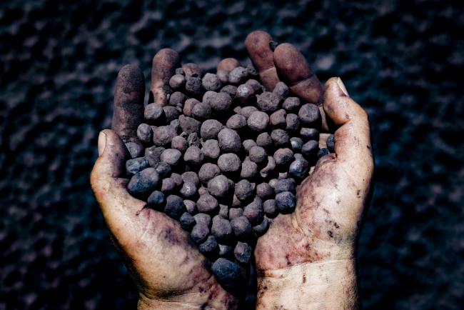 © Bloomberg. A worker holds a handful of iron ore pellets at the Yeristovo and Poltava iron ore mine, operated by Ferrexpo Poltava Mining PJSC, in Poltava, Ukraine, on Friday, May 5, 2017. China accounted for over 60% of global iron-ore demand in 2016, World Steel Association data show and was Ferrexpo's largest export-sales contributor by country.