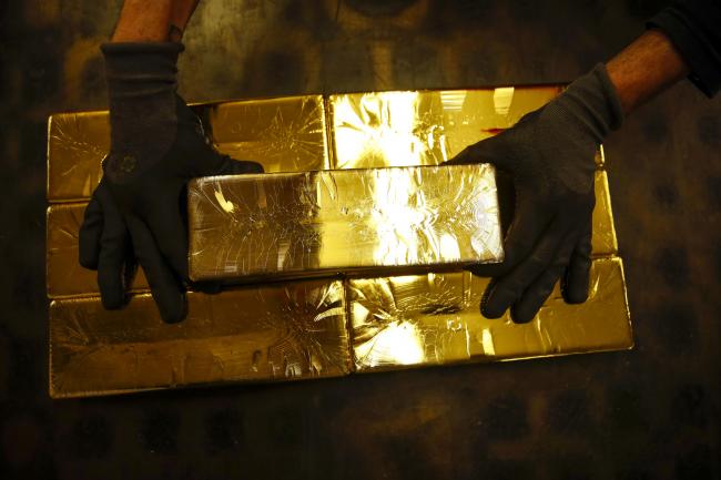 © Bloomberg. A worker stacks 12.5 kilogram gold bullion bars at the Valcambi SA precious metal refinery in Balerna, Switzerland. Photographer: Stefan Wermuth/Bloomberg