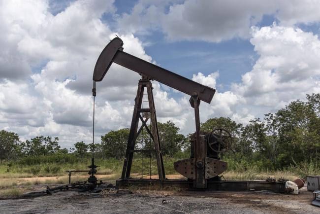 © Bloomberg. A pump jack stands near an oil spill at a Petroleos de Venezuela SA (PDVSA) facility in the Orinoco Belt of El Tigre, Venezuela, on Friday, Oct. 12, 2018. State-owned PDVSA doesn't publish statistics, but environmentalists and analysts keep seemingly endless lists of examples of wayward crude - unleashed by busted valves, ripped gaskets, and cracked pipes - that they say has polluted waterways and farmland and probably has seeped into the nation's aquifers. Photographer: Bloomberg/Bloomberg