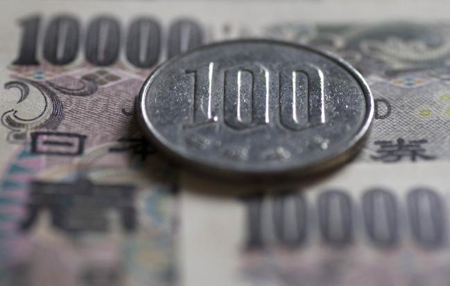 © Bloomberg. A Japanese 100 yen coin and 10,000 yen banknotes are arranged for a photograph in Tokyo, Japan, on Monday, June 20, 2016. 