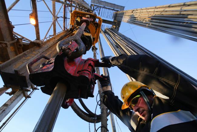 © Bloomberg. A worker uses machinery to handle oil pipes at the turntable on a drilling rig, operated by Rosneft PJSC, in the Samotlor oilfield near Nizhnevartovsk, Russia, on Tuesday, March 21, 2017.