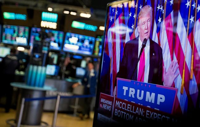 © Bloomberg. U.S. President-elect Donald Trump is seen speaking on a television on the floor of the New York Stock Exchange (NYSE) in New York, U.S., on Wednesday, Nov. 9, 2016. U.S. stocks fluctuated in volatile trading in the aftermath of Trump's surprise presidential election win, as speculation the Republican will pursue business-friendly policies offset some of the broader uncertainty surrounding his ascent.