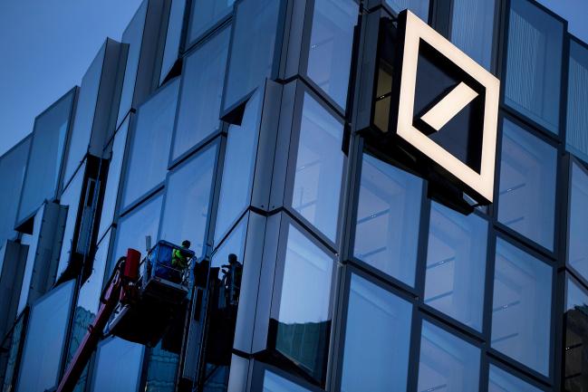 © Bloomberg. Workers stand on a hydraulic platform as they carry out maintenance on a new Deutsche Bank AG office building in Frankfurt, Germany, on Monday, Nov. 6, 2017. Demand for offices in Frankfurt and prime rents have climbed to a record as the city emerges as one of the favorites to attract financial firms from London in the run-up to the U.K.’s exit from the European Union, according to lobby group Frankfurt Main Finance.