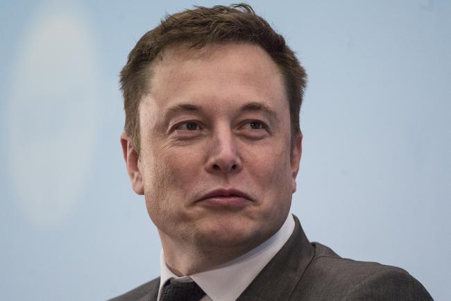 © Bloomberg. Billionaire Elon Musk, chief executive officer of Tesla Motors Inc., listens during the StartmeupHK Venture Forum in Hong Kong, China.