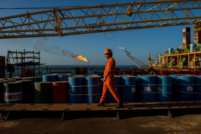 © Bloomberg. A worker passes stores of oil drums and gas flares while working aboard an offshore oil platform in the Persian Gulf's Salman Oil Field, operated by the National Iranian Offshore Oil Co., near Lavan island, Iran, on Friday, Jan. 6. 2017. Nov. 5 is the day when sweeping U.S. sanctions on Iran’s energy and banking sectors go back into effect after Trump’s decision in May to walk away from the six-nation deal with Iran that suspended them. Photographer: Ali Mohammadi/Bloomberg