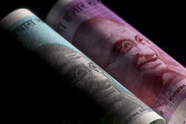 © Bloomberg. The portrait of Mahatma Gandhi is displayed on an Indian 50 rupee, left, and 2000 rupee banknotes in an arranged photograph in Bangkok, Thailand, on Wednesday, Sept. 12, 2018. India's rupee dropped to a record low before trimming last week's loss; the government unveiled measures to prop up the sagging currency, including steps to facilitate bond issuance by local companies and possible curbs on imports. Photographer: Brent Lewin/Bloomberg