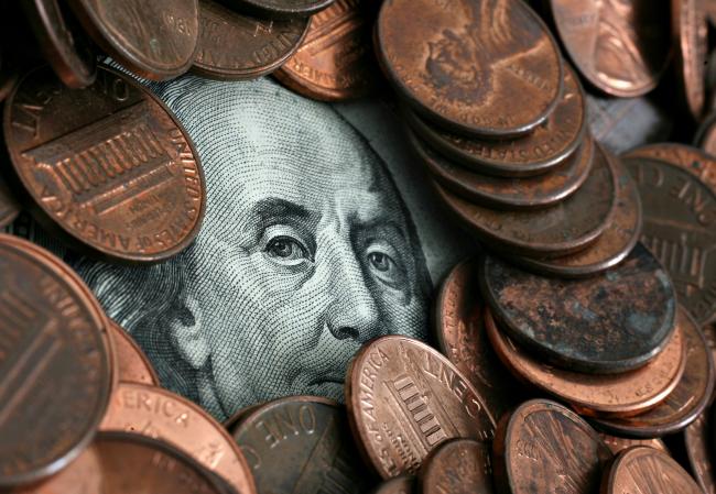 © Bloomberg. UNITED STATES - MAY 07: A portrait of Benjamin Franklin, printed on the face of U.S. one hundred dollar bill, is obscured beneath pennies in a photograph arranged on Monday, May 7, 2007, in New York. The dollar traded within a cent of its all-time low against the euro before a U.S. report forecast by economists to show new-home sales fell last month. (Photo by Stephen Hilger/Bloomberg via Getty Images)