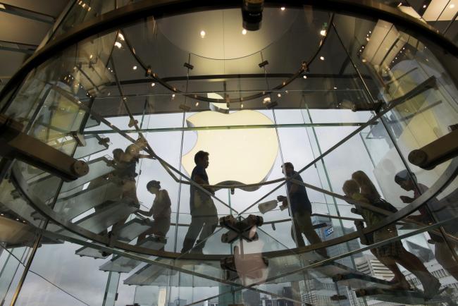 © Bloomberg. Customers walk up and down a staircase at an Apple Inc. store in Hong Kong, China, on Wednesday, July 17, 2013. Apple Inc. is expected to release earnings figures on July 23. Photographer: David Paul Morris/Bloomberg