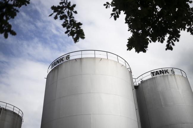 © Bloomberg. Storage silos stand at the Erik Walther GmbH oil terminal on the River Rhine in Schweinfurt, Germany, on Tuesday, June 11, 2019. Oil headed for a weekly decline as the tanker attacks in the Middle East provided only a relatively small boost to prices that have been hammered by a deepening trade war and swelling U.S. stockpiles. Photographer: Alex Kraus/Bloomberg