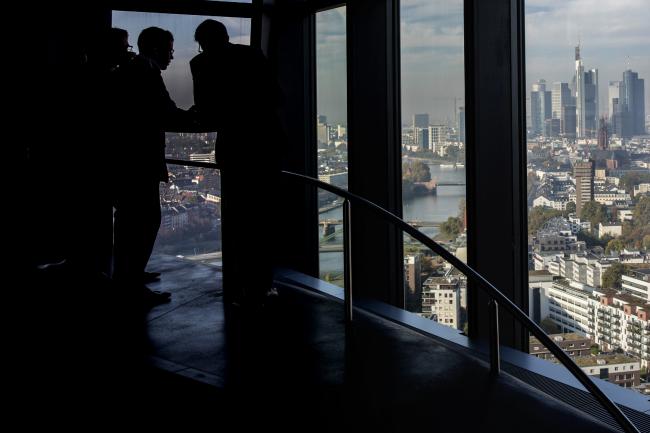 © Bloomberg. Visitors take in the city skyline view from the 15th floor pantry area inside the European Central Bank (ECB) headquarters as skyscrapers tower over commercial and residential property in Frankfurt, Germany, on Wednesday, Oct. 18, 2017. In a tweet with the hashtag #Brexit, Goldman Sachs Group Inc. Chief Executive Officer Lloyd Blankfein on Thursday hailed “great meetings” he had in Frankfurt and said he will spend a lot more time there.