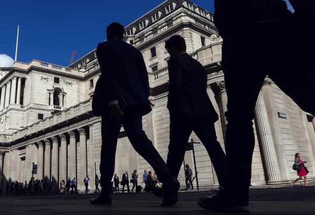 © Bloomberg. Pedestrians walk past the Bank of England (BOE) in the City of London, U.K., on Thursday, July 14, 2016. The Bank of England left its key interest rate at a record low and signaled its readying stimulus for August as the economy reels from Britains decision to quit the European Union.