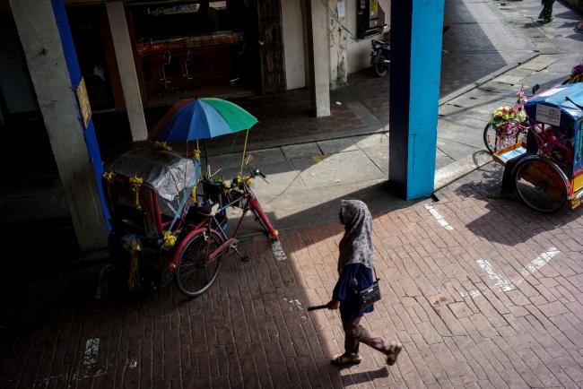 © Bloomberg. A pedestrian walks past tricycles parked outside outside the Central Market in Kuala Terengganu, Terengganu, Malaysia, on Tuesday, July 25, 2017. With a federal election due within 12 months, Prime Minister Najib Razak’s United Malays National Organisation is seeking to burnish its credentials with Muslim voters in the conservative Islamic northeastern state. Photographer: Sanjit Das/Bloomberg