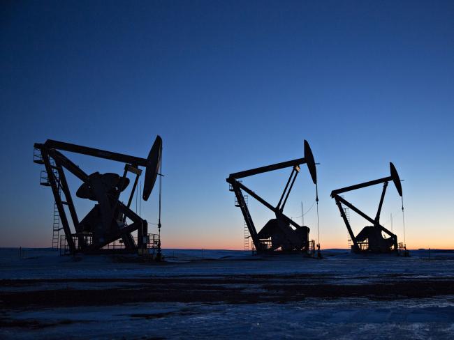 © Bloomberg. The silhouettes of pumpjacks are seen above oil wells in the Bakken Formation near Dickinson, North Dakota, U.S., on Wednesday, March 7, 2018. When oil sold for $100 a barrel, many oil towns dotting the nation's shale basins grew faster than its infrastructure and services could handle. Since 2015, as oil prices floundered, Williston has added new roads, including a truck route around the city, two new fire stations, expanded the landfill, opened a new waste water treatment plant and started work on an airport relocation and expansion project. Photographer: Daniel Acker/Bloomberg