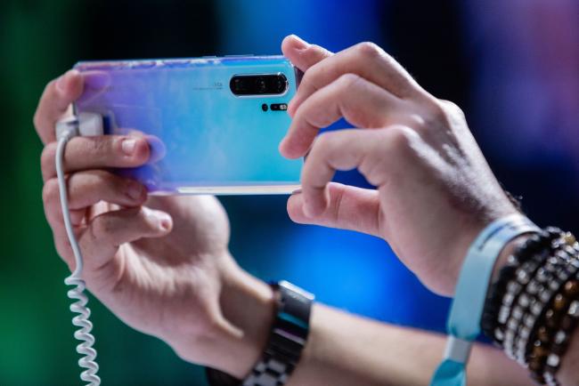 © Bloomberg. An attendee takes a photo using a P30 Pro smartphone during a Huawei Technologies Co. launch event in Paris, France, on Tuesday, March 26, 2019.  