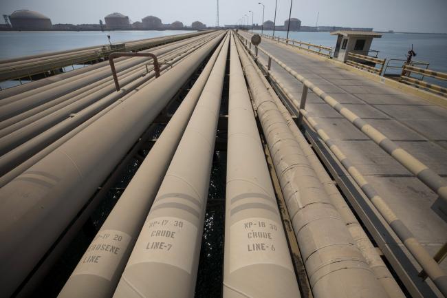 © Bloomberg. Signs for kerosene and crude oil sit on pipes used for landing and unloading crude and refined oil at the North Pier Terminal, operated by Saudi Aramco, in Ras Tanura, Saudi Arabia, on Monday, Oct. 1, 2018. Saudi Aramco aims to become a global refiner and chemical maker, seeking to profit from parts of the oil industry where demand is growing the fastest while also underpinning the kingdom’s economic diversification. 