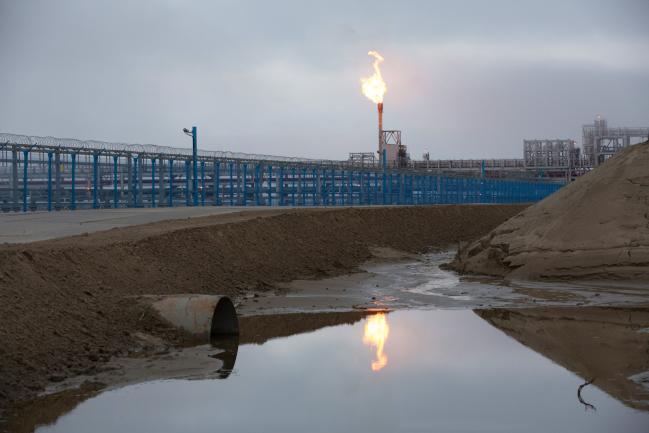 © Bloomberg. A gas flare, also known as a flare stack, burns behind security fencing at the Yamal LNG plant, operated by Novatek PJSC, in Sabetta, Russia, on Wednesday, Aug. 8, 2018.  Photographer: Andrey Rudakov/Bloomberg