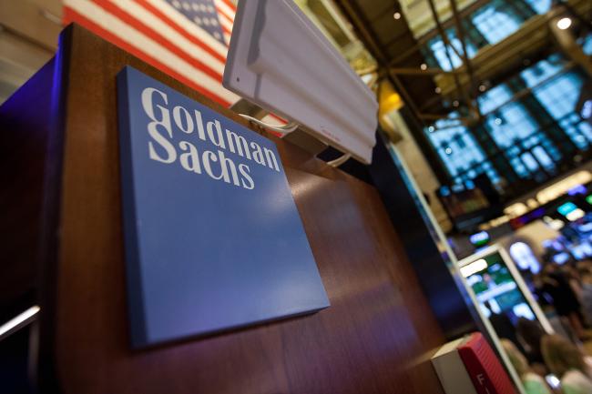 © Bloomberg. Goldman Sachs Group Inc. signage is displayed at the company's booth on the floor of the New York Stock Exchange (NYSE) in New York, U.S., on Tuesday, May 30, 2017. U.S. stocks halted a seven-day advance, while the dollar fluctuated as data showing a rebound in consumer spending offset a wider selloff in commodities. The euro slipped with equities in the region. 