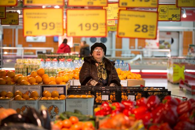 © Bloomberg. A customer browses ruble prices inside the fresh fruit area of a Magnit PJSC hypermarket store at the Hanoi-Moscow trade centre in Moscow, Russia. Photographer: Andrey Rudakov/Bloomberg