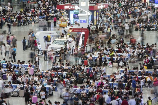 © Bloomberg. Travelers wait in the main hall of the Shanghai Hongqiao Railway Station in Shanghai, China, on Tuesday, Sept. 29, 2015. 