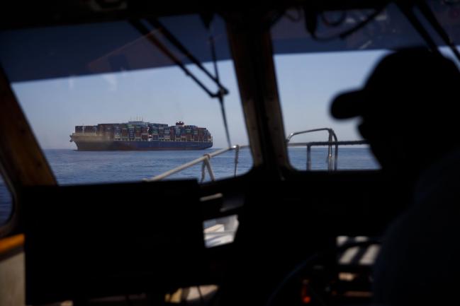 © Bloomberg. The captain of a port pilot boat approaches a container ship outside the Port of Los Angeles in Los Angeles. 