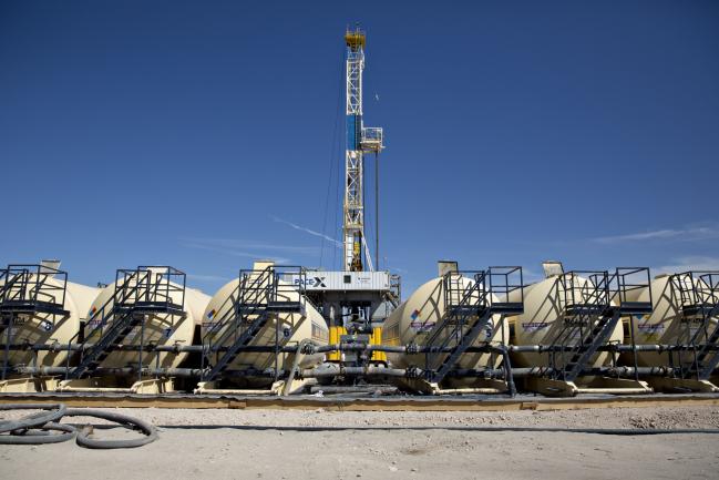 © Bloomberg. Tanks containing drilling fluid sit in a row near a Nabors Industries Ltd. rig drilling for Chevron Corp. in the Permian Basin near Midland, Texas, U.S., on Thursday, March 1, 2018. Chevron, the world's third-largest publicly traded oil producer, is spending $3.3 billion this year in the Permian and an additional $1 billion in other shale basins. Its expansion will further bolster U.S. oil output, which already exceeds 10 million barrels a day, surpassing the record set in 1970. Photographer: Daniel Acker/Bloomberg
