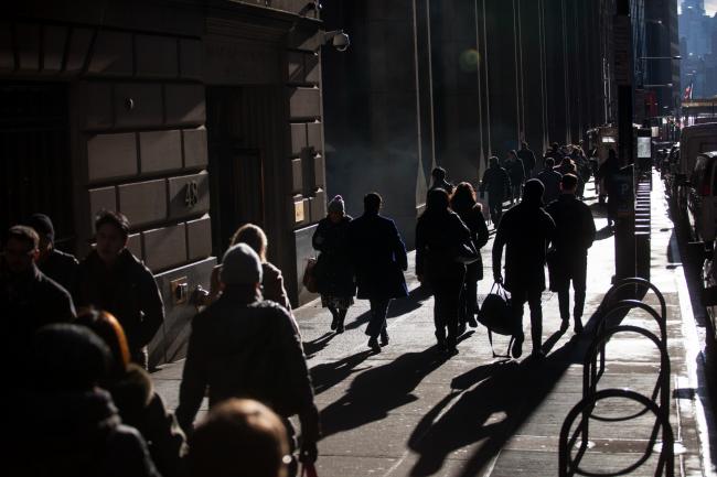 &copy Bloomberg. Pedestrians walk along Wall Street near the New York Stock Exchange (NYSE) in New York, U.S., on Monday, Feb. 5, 2018. U.S. stocks remained down after recovering from steeper early losses, while European and Asian equities slumped. 