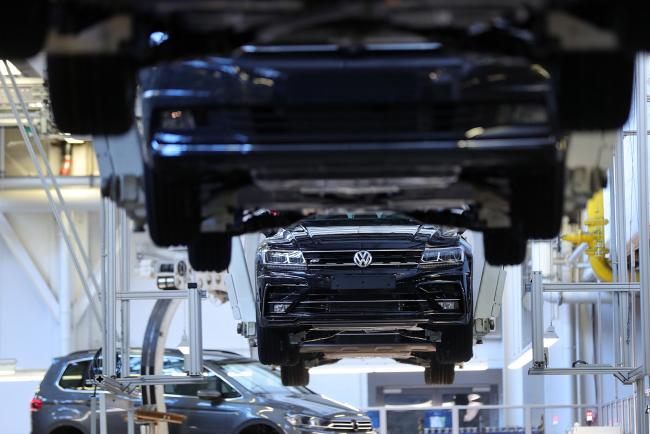 © Bloomberg. Cradles transport Volkswagen Touran R-Line Sport Utility Vehicles (SUV) on the assembly line at the Volkswagen AG (VW) factory in Wolfsburg, Germany, on Tuesday, Oct. 30, 2018. VW has managed one of the more confident outlooks in an otherwise gloomy reporting season for carmakers and suppliers. 
