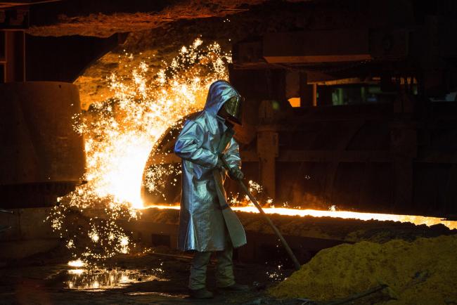 © Bloomberg. An employee wears protective clothing beside a blast furnace cast house at ThyssenKrupp AG's steel plant in Duisburg, Germany.