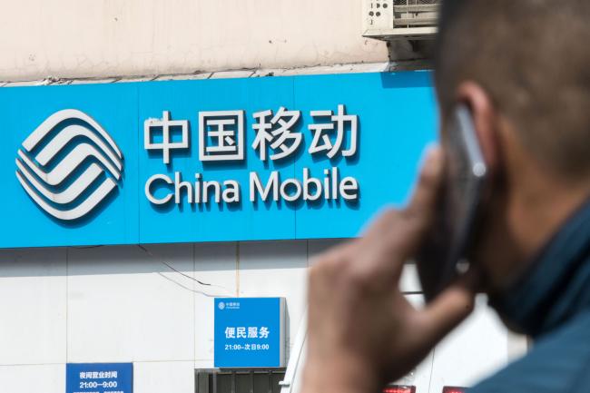 © Bloomberg. Signage for China Mobile Ltd. is displayed outside a store in Shanghai. 