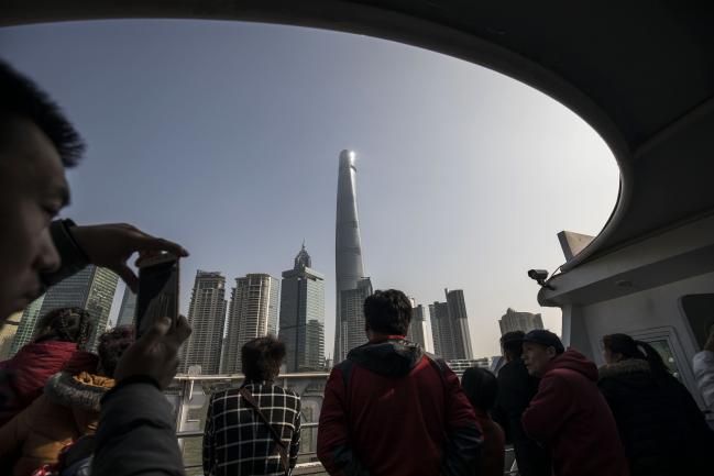 © Bloomberg. Tourists ride on a ferry crossing the Huangpu River as the Shanghai Tower, center, and other buildings stand in the Lujiazui Financial District in Shanghai, China, on Monday, Feb. 26, 2018.  Photographer: Qilai Shen/Bloomberg