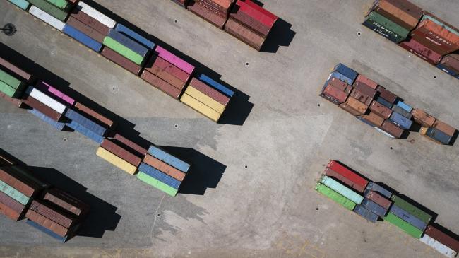 © Bloomberg. Shipping containers sit stacked at a yard near the Tianjin Port in this aerial photograph taken in Tianjin, China. 