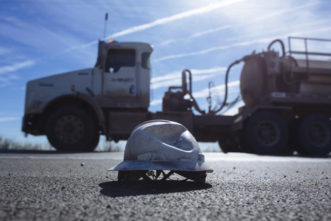 © Bloomberg. A tanker truck passes a crushed hard hat on the side of a highway in Loving County, Texas, U.S., on Saturday, Dec. 15, 2018. Once the shining star of the oil business, gasoline has turned into such a drag on profits that U.S. refiners could be forced to slow production in response. Photographer: Angus Mordant/Bloomberg