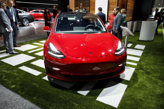 © Bloomberg. The Tesla IModel 3 vehicle is displayed during AutoMobility LA ahead of the Los Angeles Auto Show in Los Angeles, California, U.S., on Wednesday, Nov. 29, 2017. AutoMobility LA brings automakers, tech companies, designers, developers, startups, investors, dealers, government officials and analysts together to unveil the future of transportation with over 50 vehicle debuts.