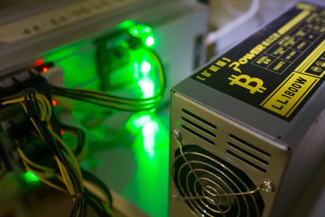 © Bloomberg. A bitcoin logo sits on a LL 1800W power unit supplying cryptocurrency mining machines at the SberBit mining 'hotel' in Moscow, Russia.