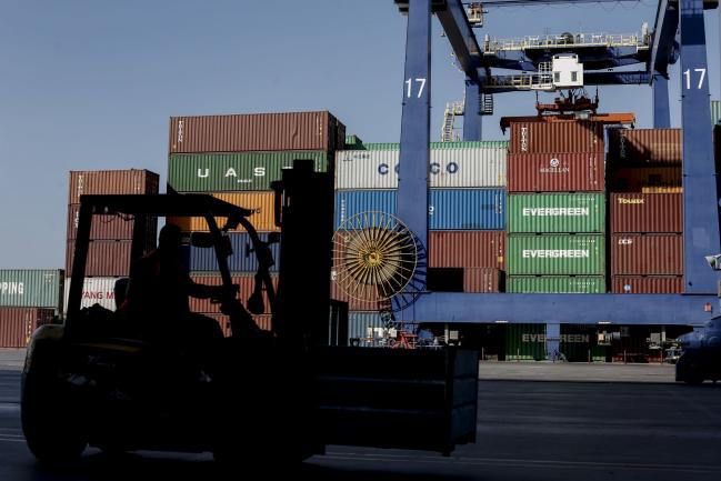 © Bloomberg. A dock worker operates a forklift truck as shipping containers stand stacked beyond at the container terminal operated by Piraeus Container Terminal SA (PCT), at the Port of Piraeus, in Piraeus, Greece, on Monday, Sept. 17, 2018.  