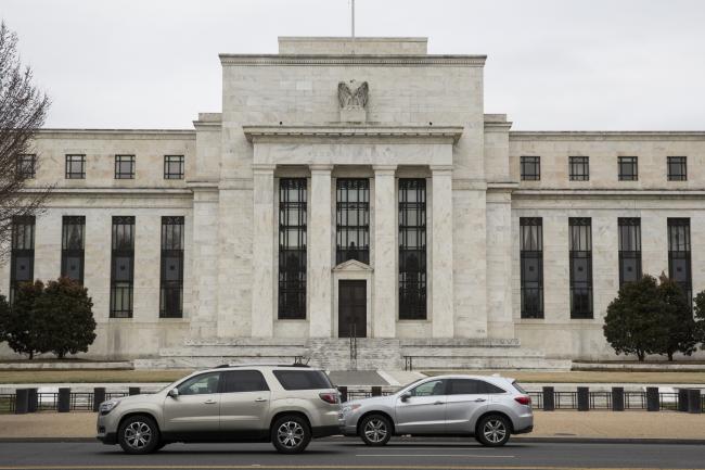 © Bloomberg. Vehicles pass in front of the U.S. Federal Reserve building in Washington, D.C., U.S. on Thursday, Feb. 22, 2018. Federal Reserve Chairman Jerome Powell testifies next week before Congress for the first time as central bank chief. Photographer: Joshua Roberts/Bloomberg