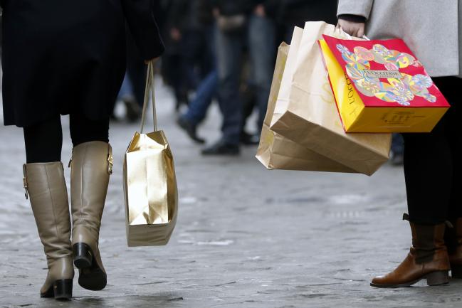 © Bloomberg. Pedestrians carry their purchases in shopping bags as they walk past stores on the first day of the New Year sales in Rome, Italy, on Saturday, Jan. 3, 2015. The euro fell to the weakest level in almost nine years versus the dollar amid speculation the European Central Bank is moving closer to large-scale sovereign-bond purchases. Photographer: Alessia Pierdomenico/Bloomberg