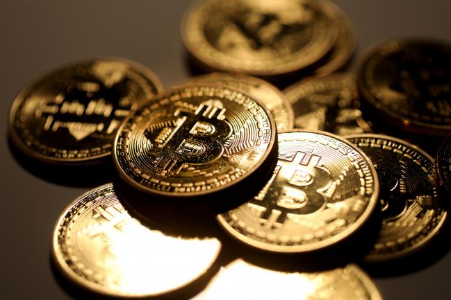 © Bloomberg. A pile of coins representing Bitcoin cryptocurrency sit grouped together in this arranged photograph in London, U.K., on Wednesday, Feb. 7, 2018. Cryptocurrencies tracked by Coinmarketcap.com have lost more than $500 billion of market value since early January as governments clamped down, credit-card issuers halted purchases and investors grew increasingly concerned that last year’s meteoric rise in digital assets was unjustified. Photographer: Chris Ratcliffe/Bloomberg