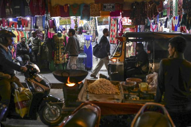 © Bloomberg. Traffic travels past vendors waiting for customers at a garment store in Raghunath Market at night in Jammu, Jammu and Kashmir, India, on Wednesday, Nov. 15, 2017. The head of treasury at State Bank of India is betting against the street. Inflation will stay anchored after the recent uptick, giving the central bank room to cut interest rates and bonds to rally, C. Venkat Nageswar said.