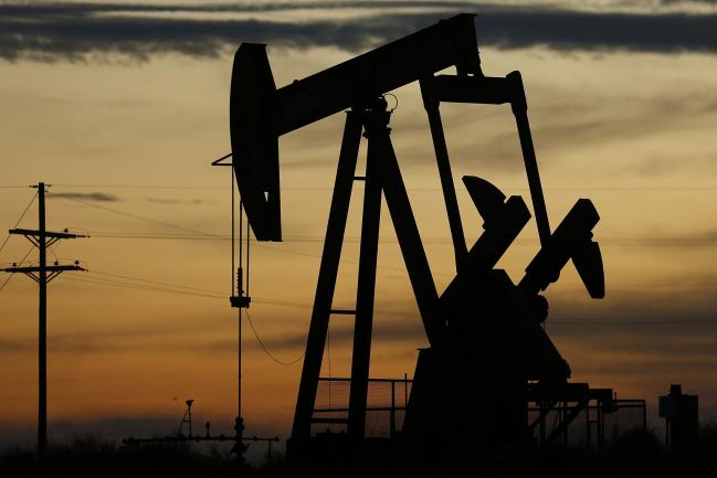 © Bloomberg. The silhouette of an electric oil pump jack is seen at dusk in the oil fields surrounding Midland, Texas, U.S., on Tuesday, Nov. 7, 2017. Nationwide gross oil refinery inputs will rise above 17 million barrels a day before the year ends, according to Energy Aspects, even amid a busy maintenance season and interruptions at plants in the U.S. Gulf of Mexico that were clobbered by Hurricane Harvey in the third quarter. Photographer: Luke Sharrett/Bloomberg