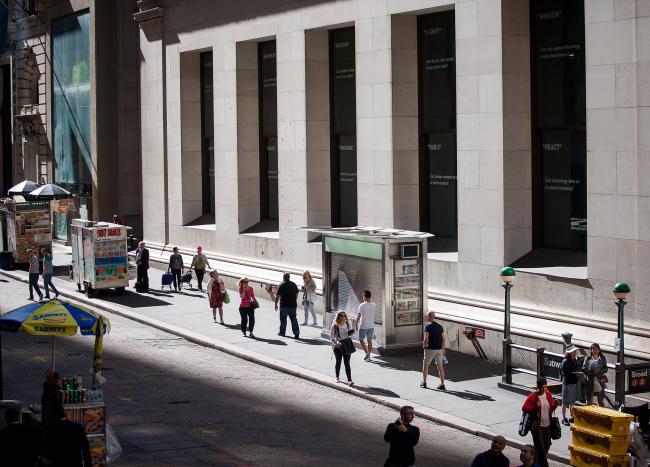 © Bloomberg. Pedestrians walk along Wall Street near the New York Stock Exchange (NYSE) in New York. Photographer: Michael Nagle/Bloomberg