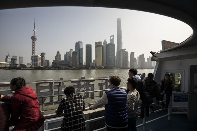 © Bloomberg. Tourists ride on a ferry crossing the Huangpu River as the Oriental Pearl Tower, left, the Shanghai Tower, right, and other buildings stand in the Lujiazui Financial District in Shanghai, China, on Monday, Feb. 26, 2018. Xi Jinping's decision to cast aside China's presidential term limits is stoking concern he also intends to shun international rules on trade and finance, even as he champions them on the world stage. Photographer: Qilai Shen/Bloomberg