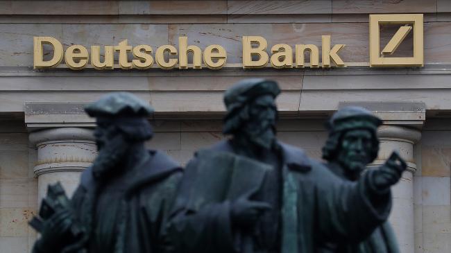 © Bloomberg. The Gutenberg memorial statue stands outside a Deutsche Bank AG bank branch in Frankfurt, Germany. Photographer: Krisztian Bocsi/Bloomberg