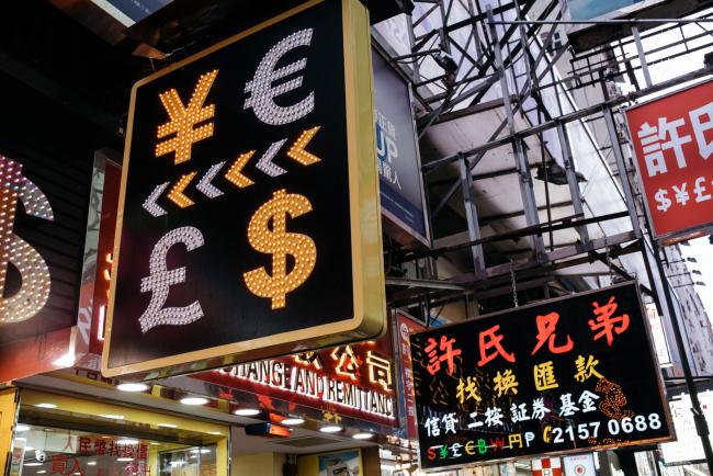 © Bloomberg. A sign featuring Japanese yen, top left, euro, top right, British pound sterling, bottom left, and U.S. dollar is displayed at a currency exchange store in Hong Kong, China. Photographer: Anthony Kwan/Bloomberg