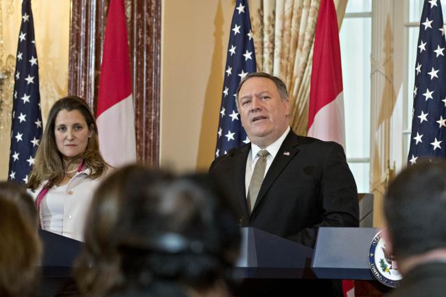 © Bloomberg. Mike Pompeo, U.S. secretary of state, speaks as Chrystia Freeland, Canada's minister of foreign affairs, left, listens at a news conference during a U.S.-Canada 2+2 ministerial meeting at the State Department in Washington, D.C. on Dec. 14, 2018. 