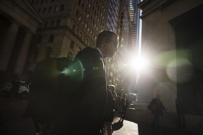 © Bloomberg. A pedestrian walks on Wall Street near the New York Stock Exchange (NYSE) in New York, U.S., on Friday, Oct. 19, 2018. The rebound in U.S. stocks lost steam as investors assessed the latest batch of corporate earnings and simmering geopolitical tensions ahead of the weekend. Photographer: Victor J. Blue/Bloomberg