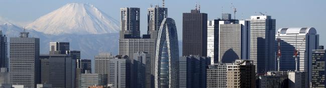 © Bloomberg. Mount Fuji and buildings in the Shinjuku district are reflected on a table at an observation deck in Tokyo, Japan.