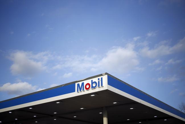 © Bloomberg. Signage is displayed at an Exxon Mobil Corp. gas station in Columbus, Indiana, U.S., on Tuesday, Jan. 29, 2019. Soaring production in North America's most prolific oil field helped propel Exxon Mobil Corp. to bigger-than-expected fourth-quarter profits. 